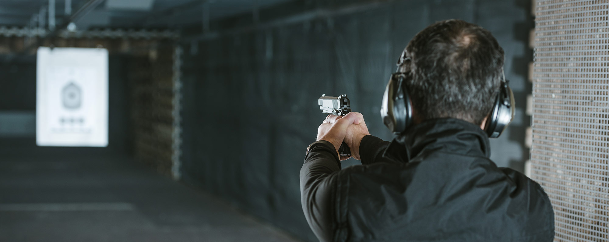 Man shooting pistol at target image